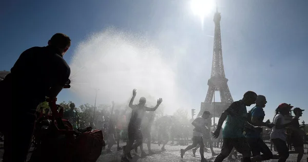 Rafraîchissement par brumisation lors d'une course, avec la tour Eiffel en arrière-plan.