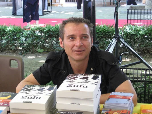 Caryl Férey au Festival International du roman Noir de Frontignan, entouré de ses livres 'Zulu'.
