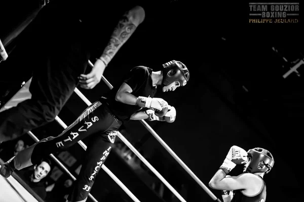 Moment dynamique d'un combat de savate boxe française en noir et blanc.