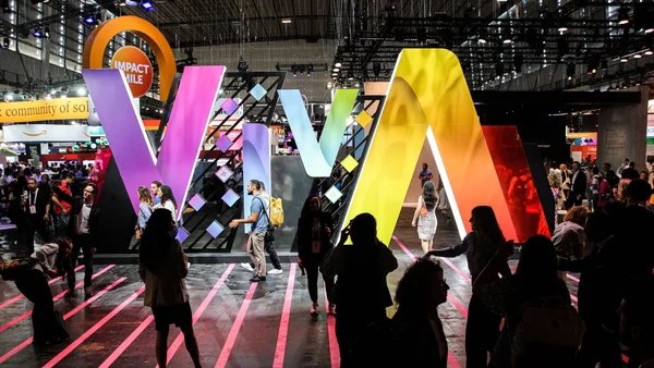 L'emblématique installation 'VIVA' illuminée au cœur du salon VivaTech, attirant les participants sous les projecteurs.