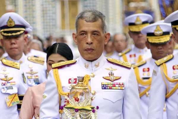 Le roi Maha Vajiralongkorn lors d'une cérémonie officielle, flanqué de dignitaires en uniforme