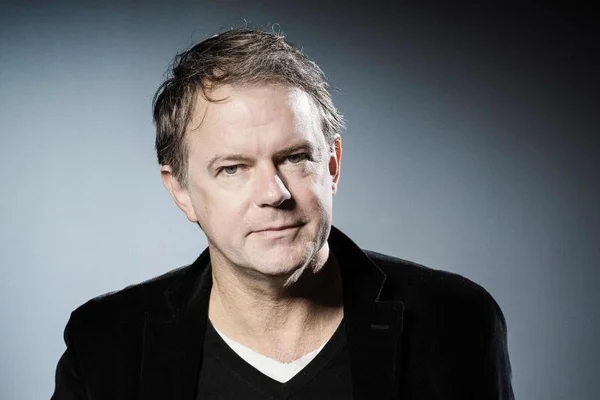 Yannick Haenel, veste noire sur fond gris.