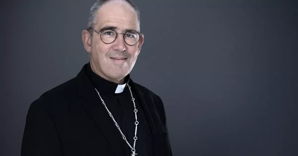 Portrait de Mgr Matthieu Rougé, évêque, souriant en tenue ecclésiastique.
