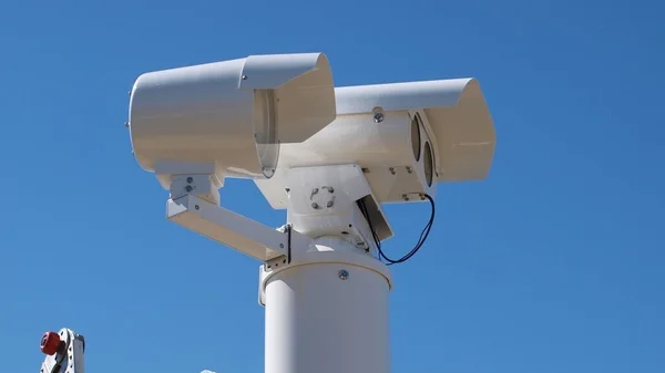 Système de surveillance à double capteur installé sur un poteau, utilisé pour la lecture automatique des plaques d'immatriculation.