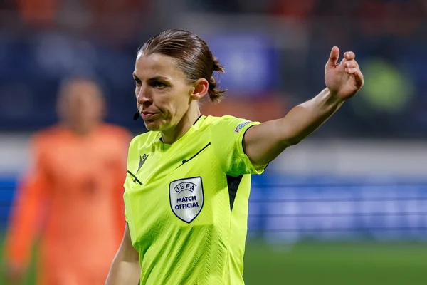 Stéphanie Frappart arbitrant un match en tenue UEFA jaune fluo.