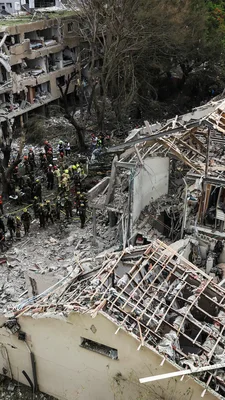 Équipes de secours sur les ruines d'un bâtiment effondré en Iran après une attaque.