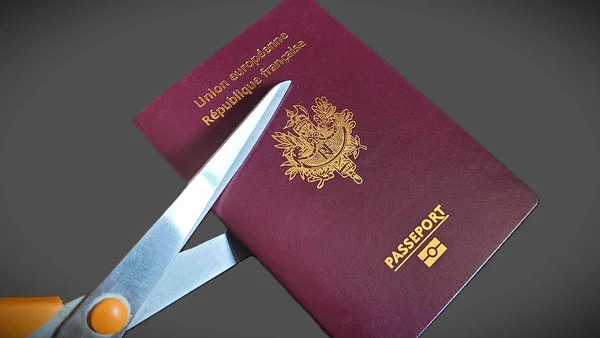 Décision de déchéance de nationalité symbolisée par la découpe d'un passeport français.