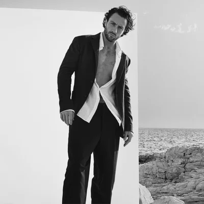 Aaron Taylor-Johnson en noir et blanc devant un paysage marin.