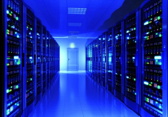 Allée de serveurs dans un centre de données, avec un éclairage bleu et une porte au bout du couloir.