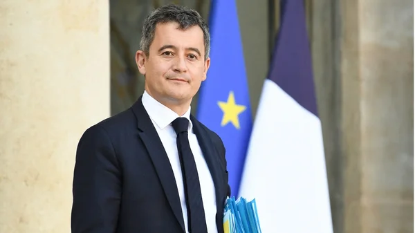 Gérald Darmanin, ministre de la Justice, lors d'une prise de fonction officielle avec les drapeaux français et européen.