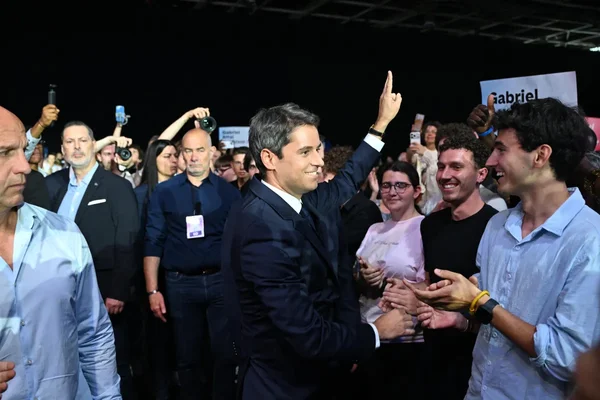 Gabriel Attal serrant la main de ses partisans lors d'un meeting de campagne.