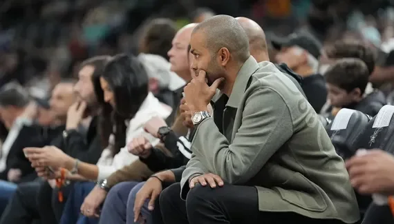 Tony Parker, concentré, dans les tribunes lors d'un match de basket.