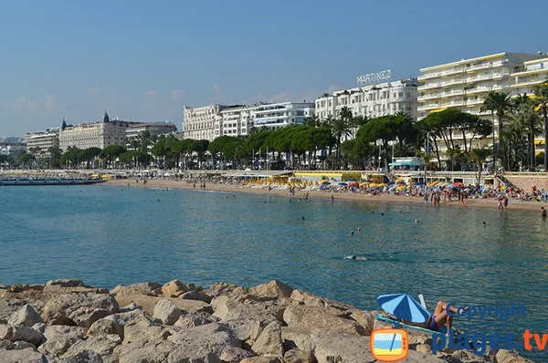 La Croisette à Cannes avec l'hôtel Martinez, baigneurs et plage animée.