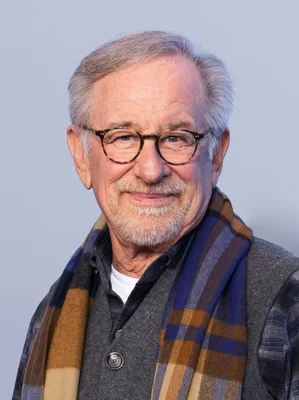 Steven Spielberg en cardigan et écharpe à carreaux.