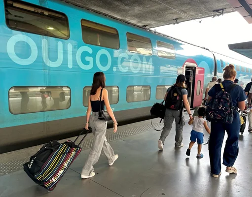 Voyageurs se dirigeant vers un train OUIGO sur un quai de gare, alors que la SNCF anticipe les effets de la canicule.