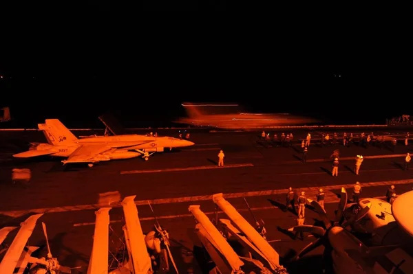 Un F/A-18 Hornet américain sur le pont d'un porte-avions lors d'opérations en Syrie.