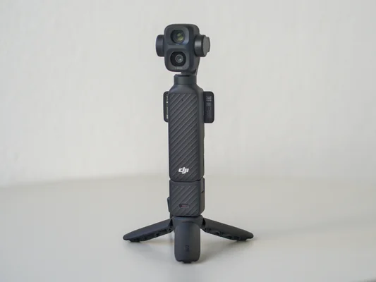 DJI Osmo Pocket 4P sur son mini-trépied, présentant son format de poche et son double objectif.