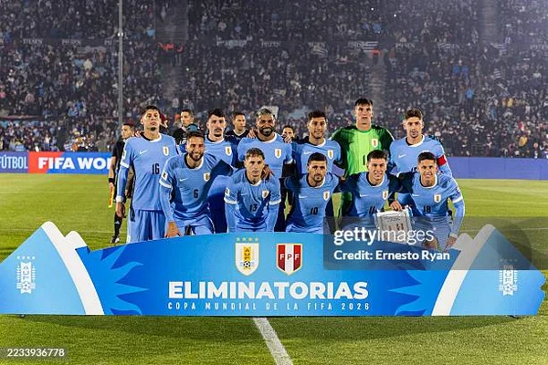 Photo d'équipe de l'Uruguay devant une bannière des éliminatoires de la Coupe du monde 2026.