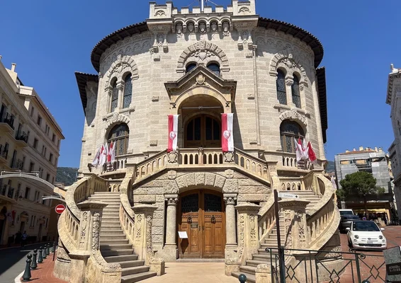 Bâtiment historique avec double escalier et drapeaux.