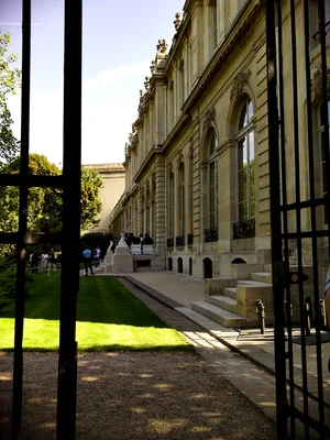 L'Assemblée nationale vue depuis les grilles, avec des personnes rassemblées sur les marches.