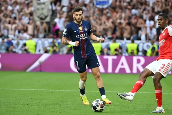 Khvicha Kvaratskhelia dribble face à un joueur d'Arsenal lors d'un match de Ligue des champions.