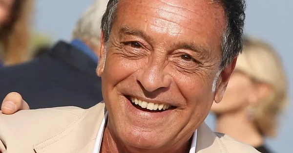 Portrait récent de Félix Gray, souriant, vêtu d'une veste beige.