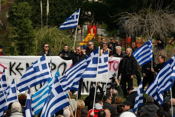Rassemblement de l'Aube Dorée avec une banderole et des drapeaux grecs.