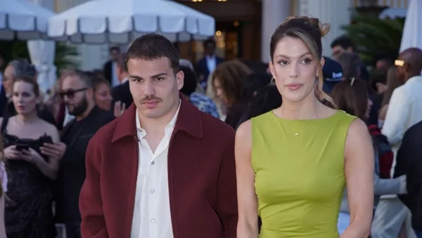 Antoine Dupont et Iris Mittenaere posant côte à côte lors d'un événement en extérieur.