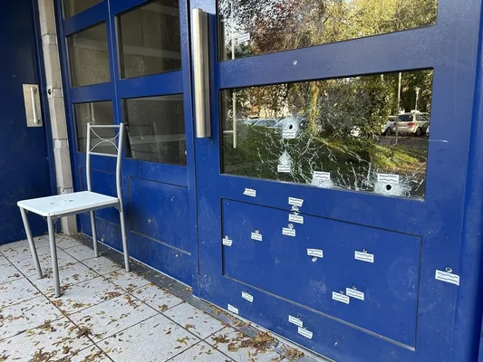 Porte d'immeuble mitraillée dans le nord de Nantes, avec 21 impacts de balles et des pastilles d'identification.