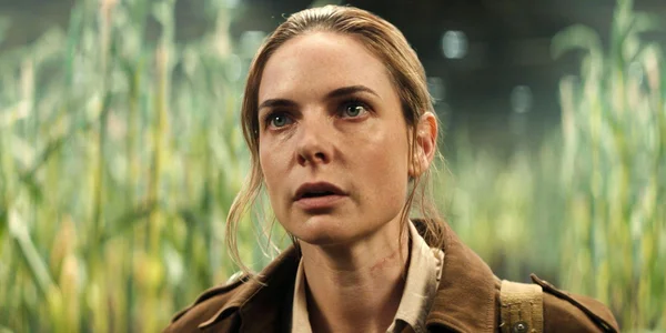 Rebecca Ferguson dans un plan rapproché, vêtue d'une veste brune, regardant vers le haut avec une expression intense.