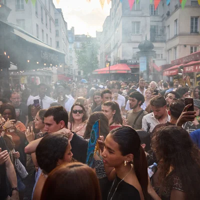 Affluence dans les rues de Paris pour la Fête de la musique, sous une chaleur accablante.