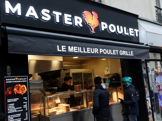 Devanture d'un restaurant Master Poulet à Paris, avec des clients en attente.