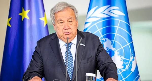António Guterres, Secrétaire général de l'ONU, s'exprimant depuis un pupitre avec les drapeaux de l'UE et de l'ONU.