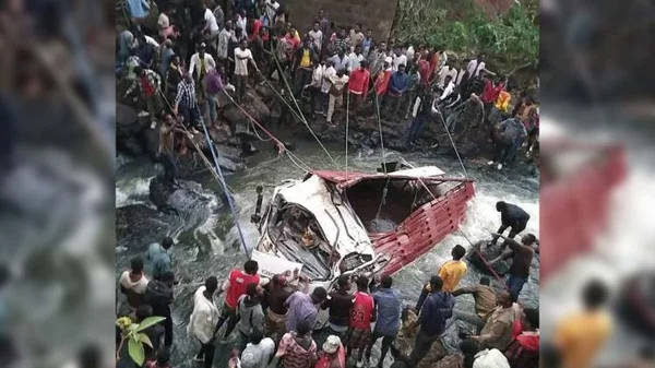 Des sauveteurs tentent de remorquer un bus accidenté hors de l'eau à l'aide de cordes, en Éthiopie.