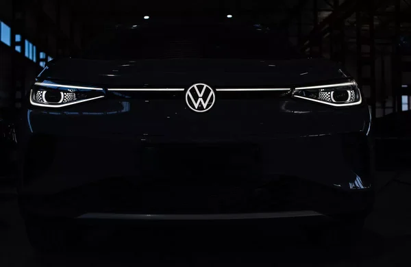 Volkswagen sombre avec phares et logo illuminés.