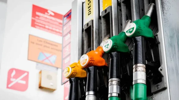 Pistolets de pompe à essence de différentes couleurs pour divers carburants.
