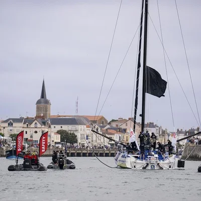 Le voilier vainqueur escorté par les bateaux de sécurité dans le port des Sables-d'Olonne.