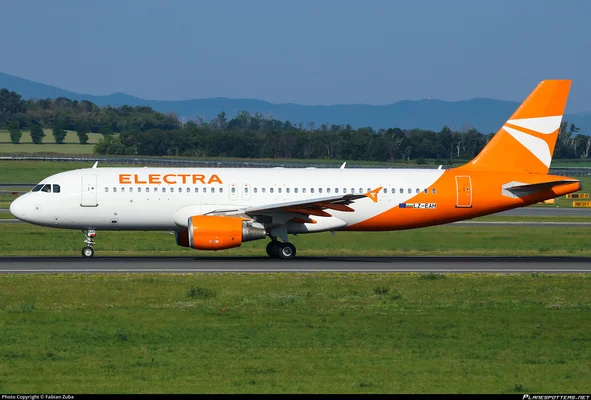 L'Airbus A320 d'Electra Airways roulant sur une piste, entouré de verdure et de montagnes.