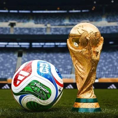 Le trophée de la Coupe du monde et le ballon officiel Trionda présentés sur la pelouse du stade.