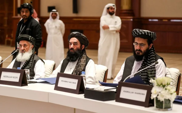 Réunion de responsables talibans autour d'une table de conférence.