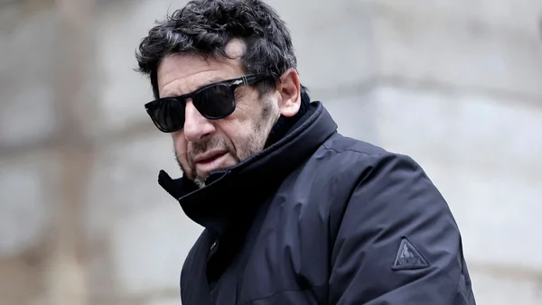 Patrick Bruel, lunettes de soleil et veste noire.