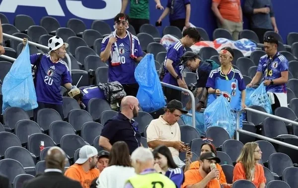 Des supporters japonais nettoient les tribunes après le match nul contre les Pays-Bas lors de la Coupe du monde.