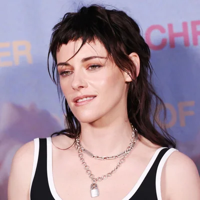 Kristen Stewart arborant un look années 70, cheveux mouillés et bijoux argentés.