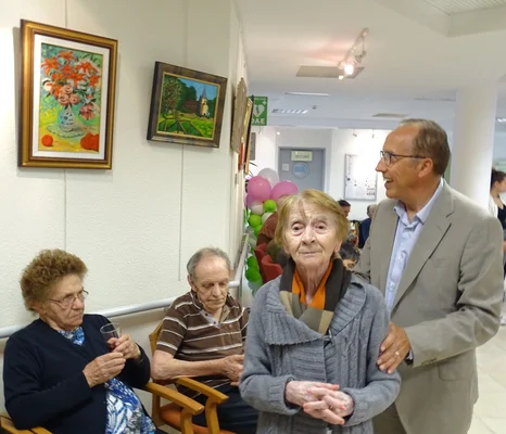 Moment de convivialité dans un Ehpad, avec une résidente et un visiteur.