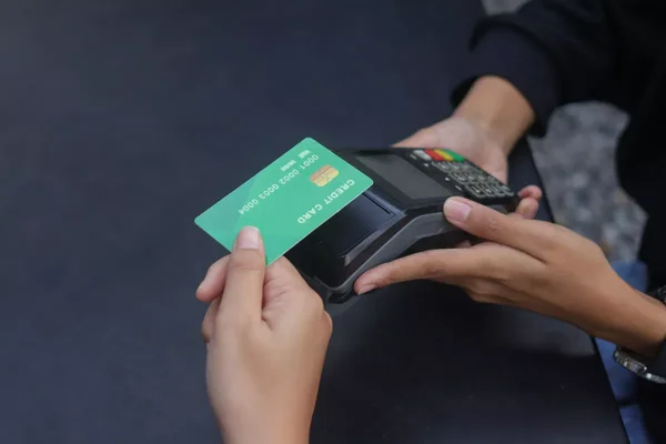 Paiement par carte de crédit sur un terminal de point de vente, symbole des transactions sans espèces.