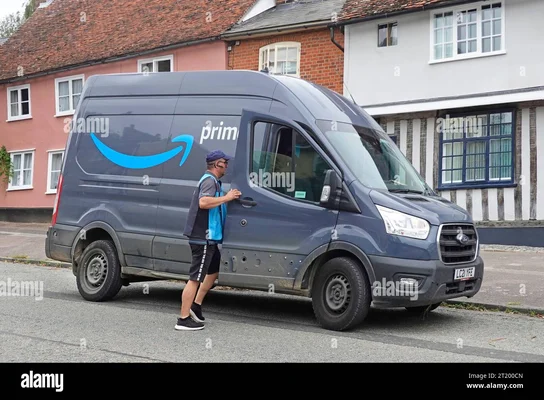 Chauffeur de livraison Amazon Prime retournant à sa camionnette dans un village résidentiel en Angleterre.