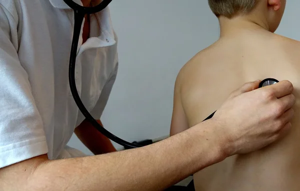 Examen médical d'un enfant par un médecin au stéthoscope.