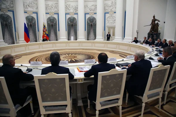 Réunion de responsables russes dans une salle de conférence officielle, illustrant l'entourage de Vladimir Poutine.