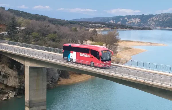 Un autocar BlaBlaBus roule sur un pont, illustrant l'offre de transport longue distance de BlaBlaCar.