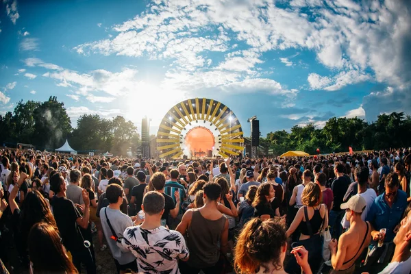 Vue d'ensemble du public du festival Peacock Society en 2022, devant la scène principale à l'arche solaire jaune.